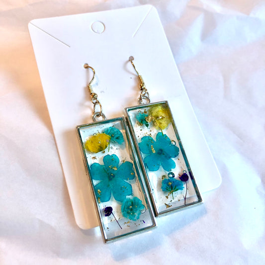 Silver bezel rectangles with beautiful blue yellow and purple flowers inside. Medium size.